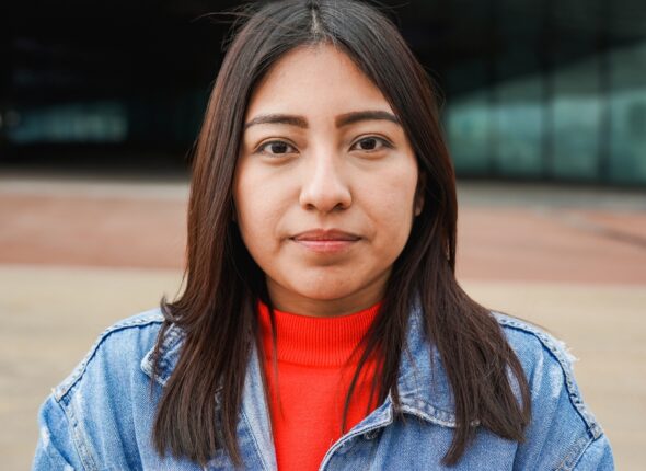 Portrait,Of,Native,American,Woman,Looking,On,Camera,With,City